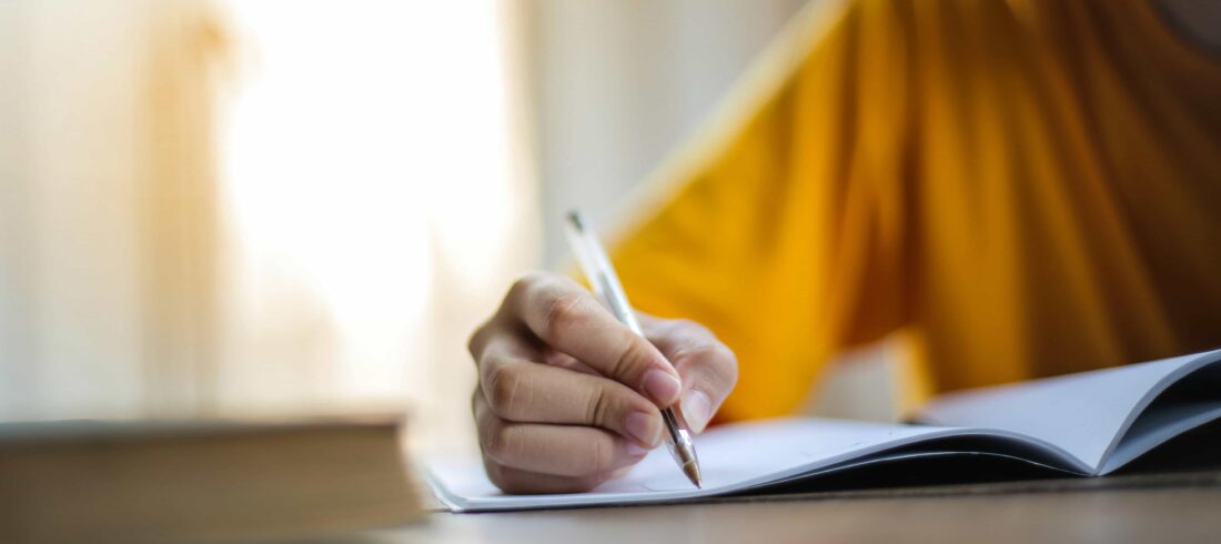 persona escribiendo sobre una hoja con un bolígrafo