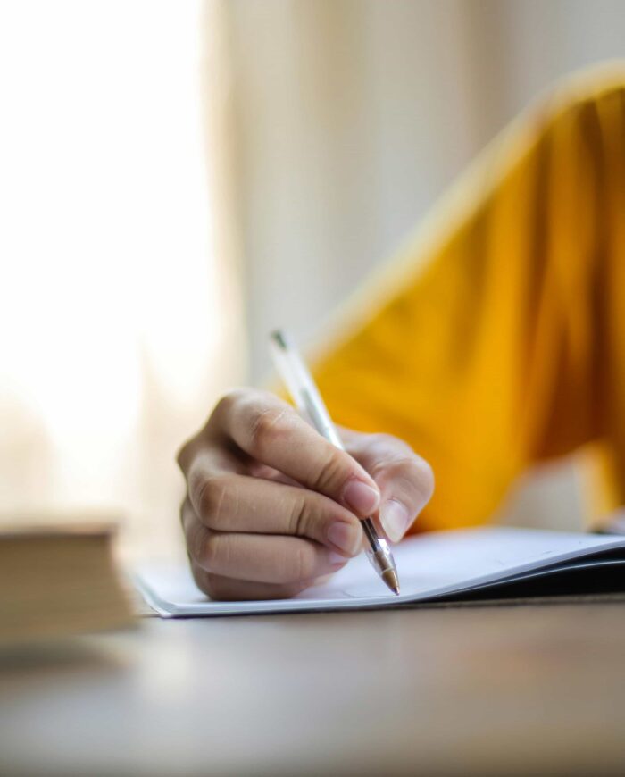 persona escribiendo sobre una hoja con un bolígrafo